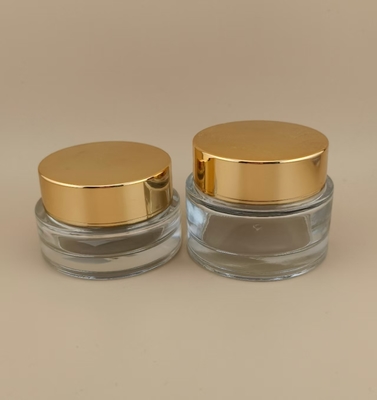 Durchsichtige Glascreme-Glasflasche mit goldenem Schraubdeckel für weibliche Lotion